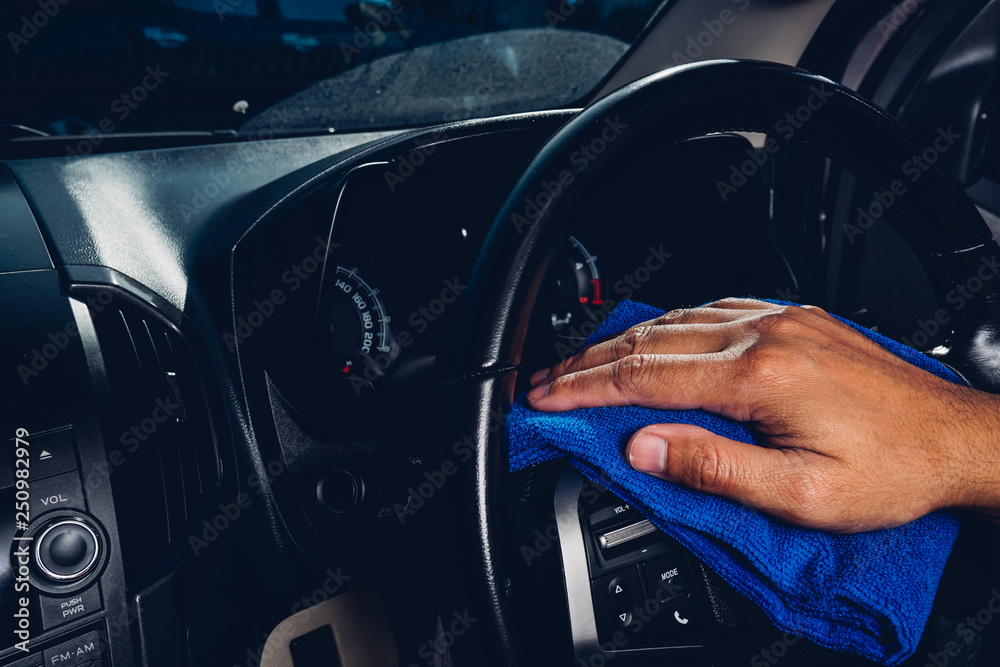 Worker man cleaning dust interior by cloth microfiber inside car