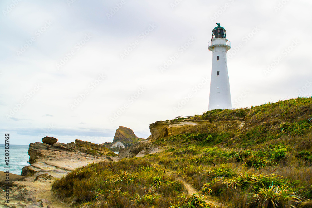 Landmarks of New Zealand, North Island. Panoramic scenic landscape view of the white lighthouse in Castlepoint village in Wairarapa/Wellington area or region. Tourist popular attraction/destination.