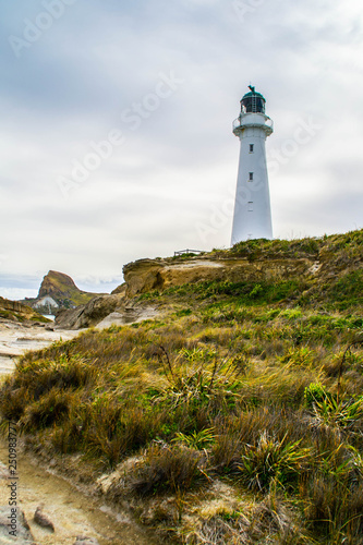 Landmarks of New Zealand, North Island. Panoramic scenic landscape view of the white lighthouse in Castlepoint village in Wairarapa/Wellington area or region. Tourist popular attraction/destination.