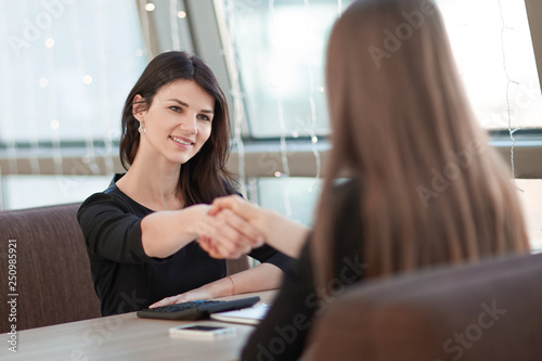 two business women shaking hands at an informal meeting. Free Download two business women shaking hands at an informal meeting. - GFXLoad