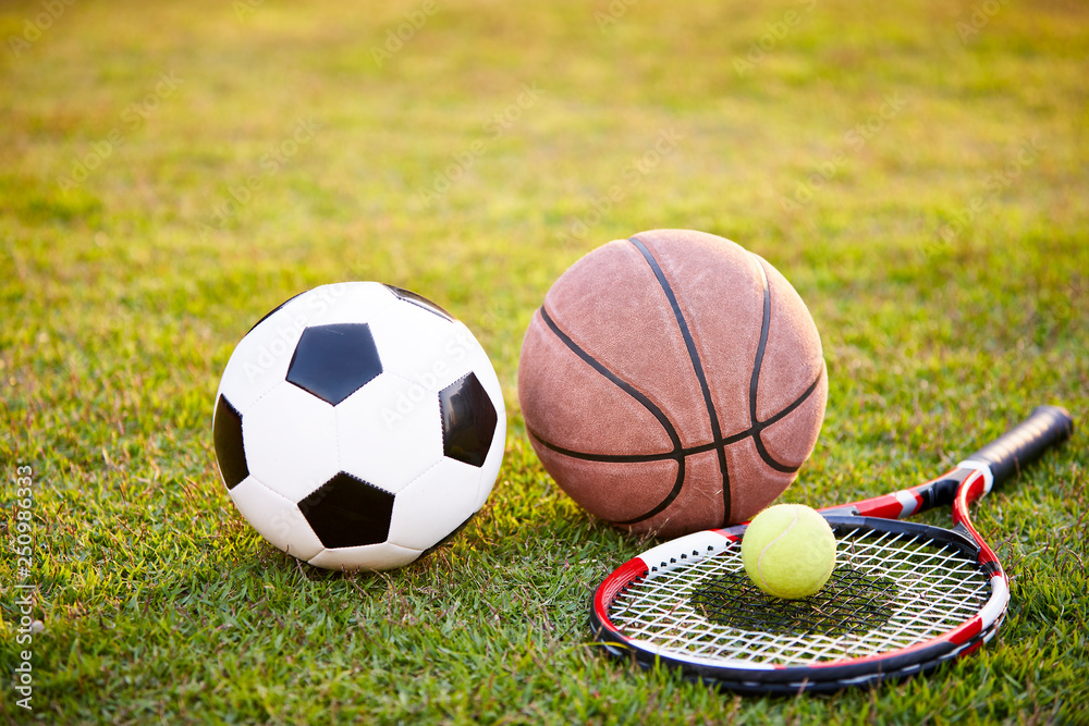 football basketball and tennis ball and racket on grass