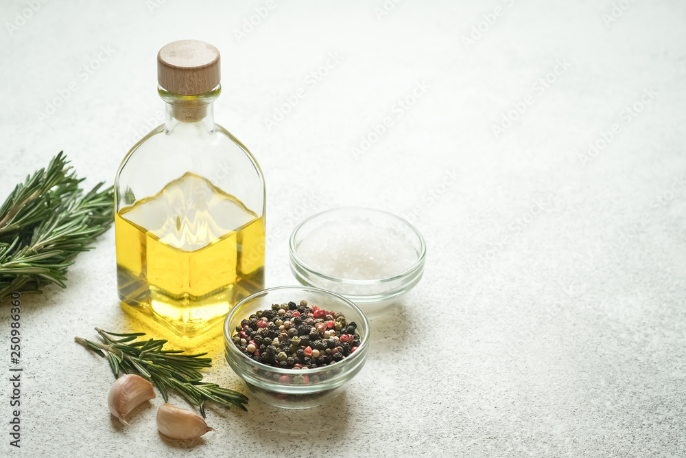 Fresh rosemary herb with oil and spices on a light background. Fresh rosemary herb with oil and spices on a light background.