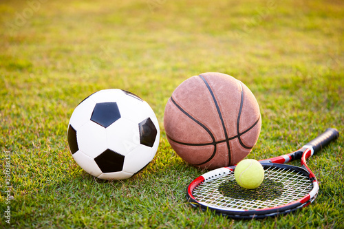 football basketball and tennis ball and racket on grass