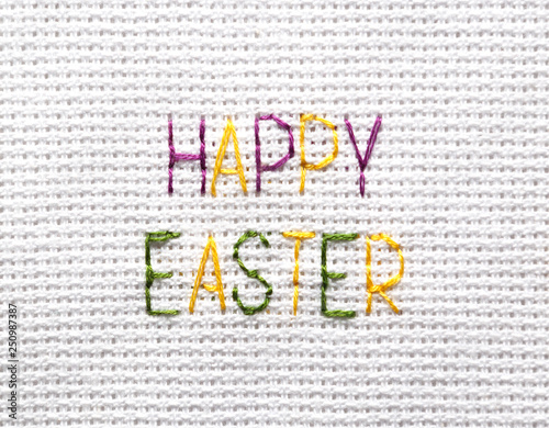 The inscription "Happy Easter" is embroidered with colored threads on white fabric.