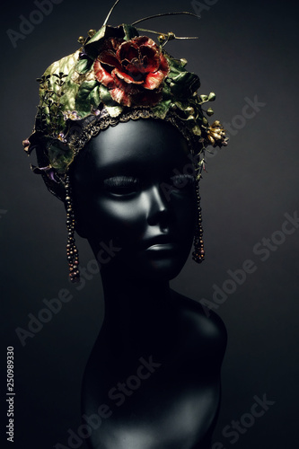 Head of mannequin in creative kokoshnick with flower and leaves