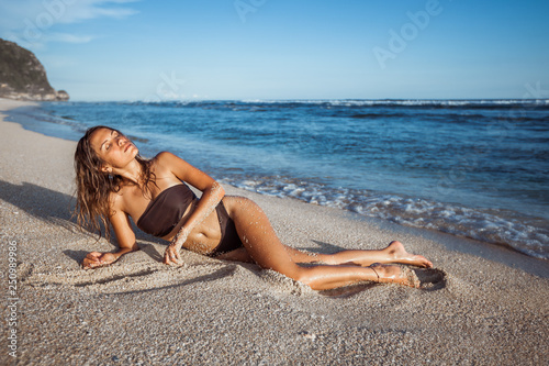 sexy girl in brown swimsuit sunbathing on the beach