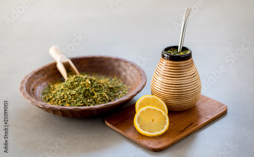 Traditional Yerba Mate tea with matero and bombilla, healthy, energy boosting beverage drink on neutral stone gray background.