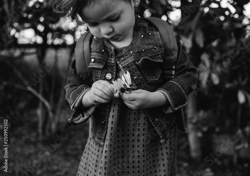 Niña pequeña con una flor en la mano