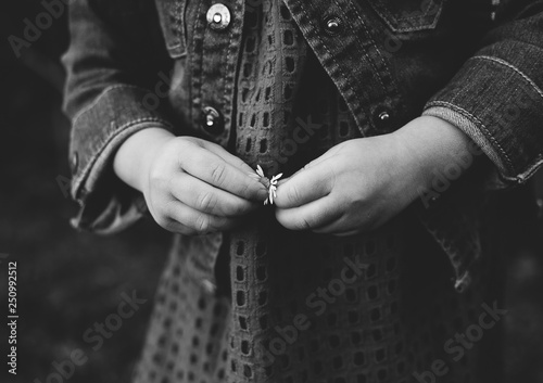Hands of little girl holding a flower