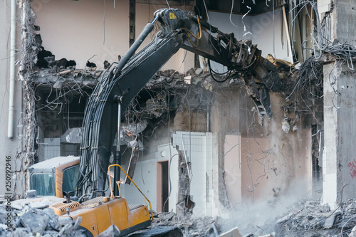 Photo of building demolition excavator/destruction of a building, house ruins, reconstruction, bricks and metal, abandoned hotel, heavy machinery,construction equipment, hydraulic excavator, bulldozer