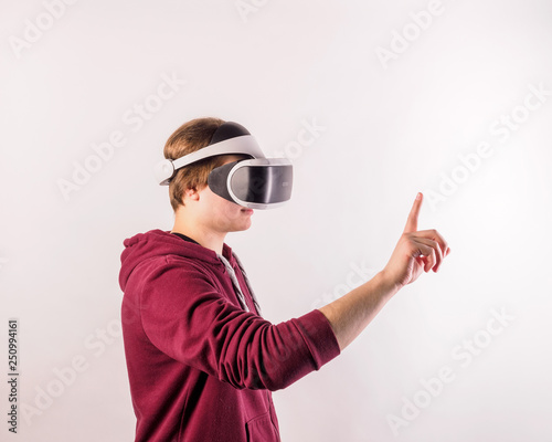 Teenage student man virtual reality headset or 3d glasses, playing video game, gesturing with his hands and catching something.