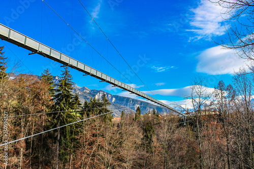 a spectacular suspension bridge (pedestrian), in iron, in the municipality of Sigriswil, in the district of Thun in the canton of Bern, Switzerland. View of mountains and lake in winter.