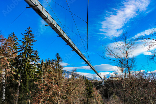 a spectacular suspension bridge (pedestrian), in iron, in the municipality of Sigriswil, in the district of Thun in the canton of Bern, Switzerland. View of mountains and lake in winter.