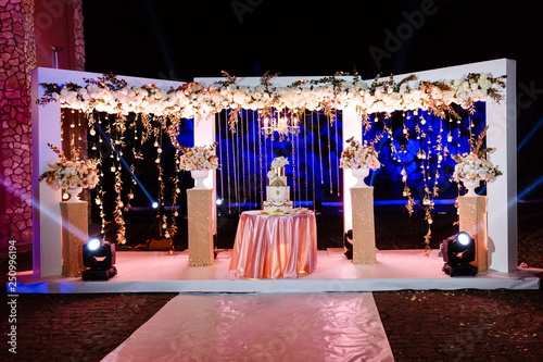 Table with a wedding cake, candles, light and flowers. wedding decoration