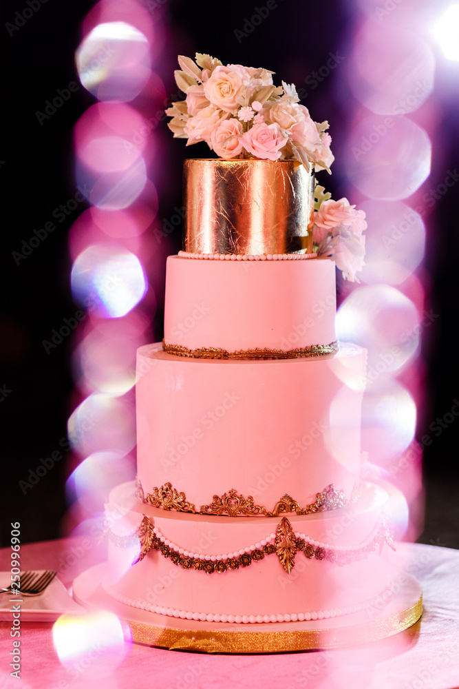 Fototapeta premium Closeup of white wedding cake with flowers. Big wedding cake. Decor trends. Wedding ceremony.