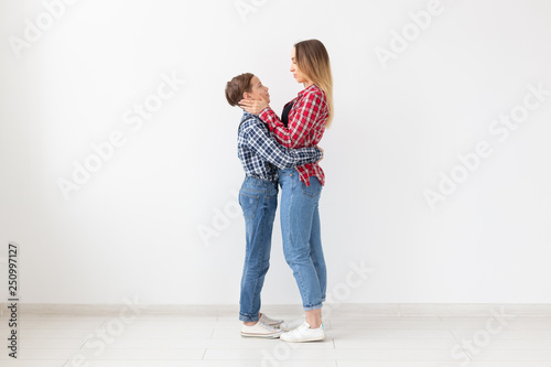 Family, fashion and mother day concept - teen boy hugging his mom on white background