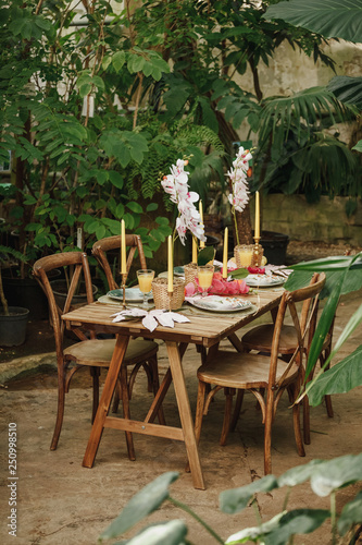 Table and chairs in a tropical garden before the wedding dinner