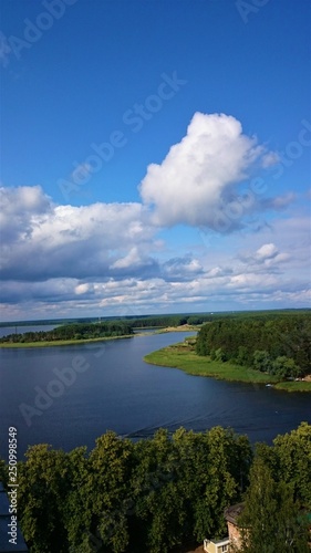 Blue sky and blue lake in summer. White clouds are reflected in the water. The famous lake Seliger. Russia.
