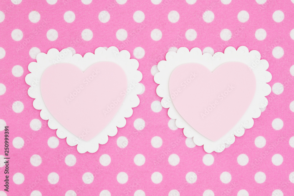 Two blank white and pink hearts on bright pink and white polka dot fabric background