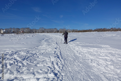 Skier on a walk on a snowy field. Ski walk. Beautiful winter day.