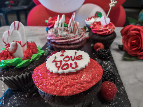 Chocolate love decorated cupcakes with hearts and balloons and roses
