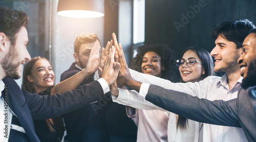 Happy office workers giving high five at meeting photo