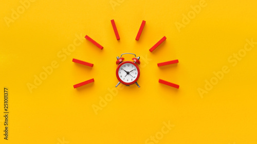 Alarm clock with red dominoes on yellow background