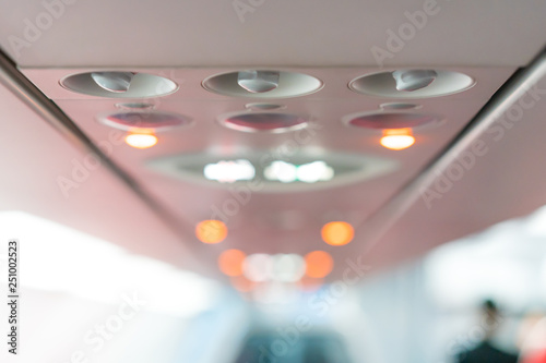 closeup airplane Console panel; lamp, light, need help button, air condition, sefty belt and no smoking lighting sign. photo