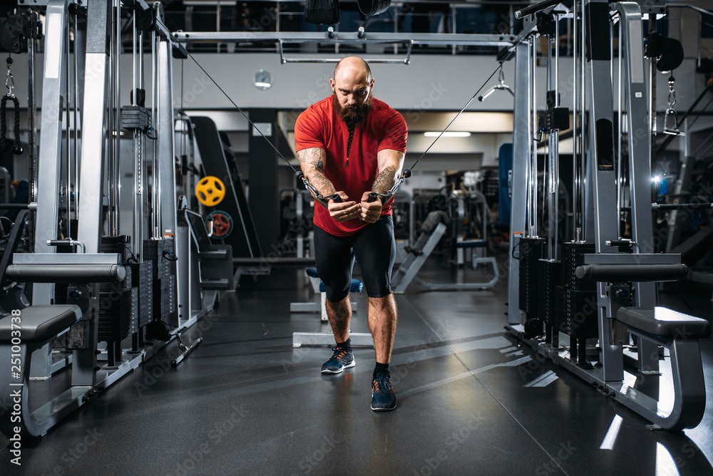 Strong athlete, training on exercise machine Strong athlete, training on exercise machine