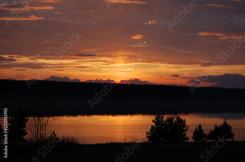 puesta del sol rosa morada en rusia, lago de otoño, foto contra sol colores maravillos asombrosos rojos © Konstantin
