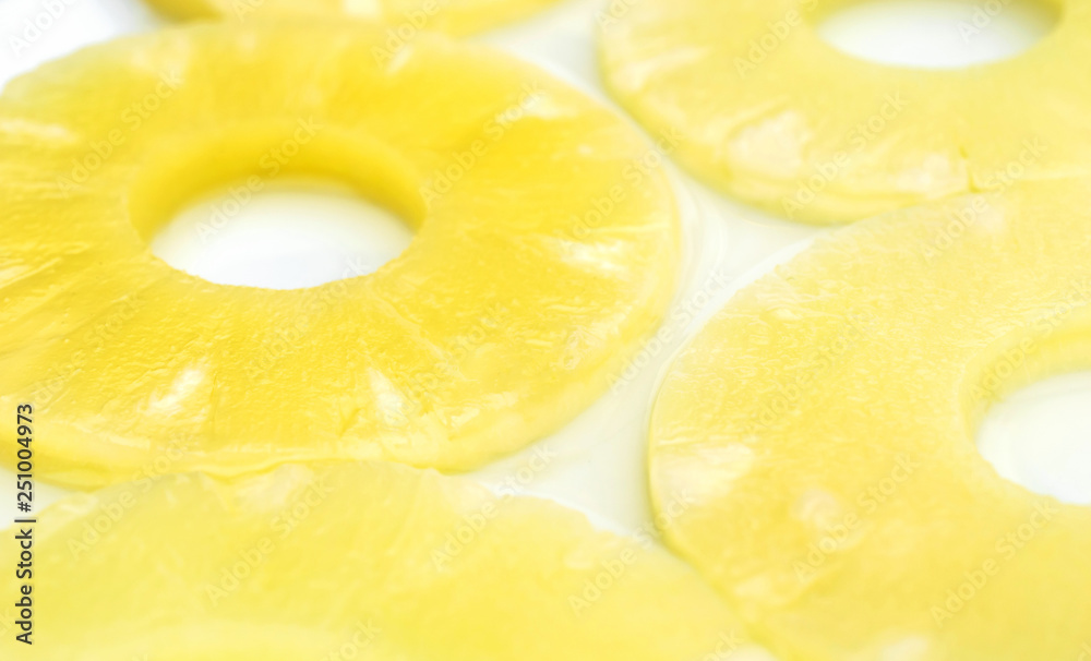 Abstract food background of pineapple rings in syrup. Close up.