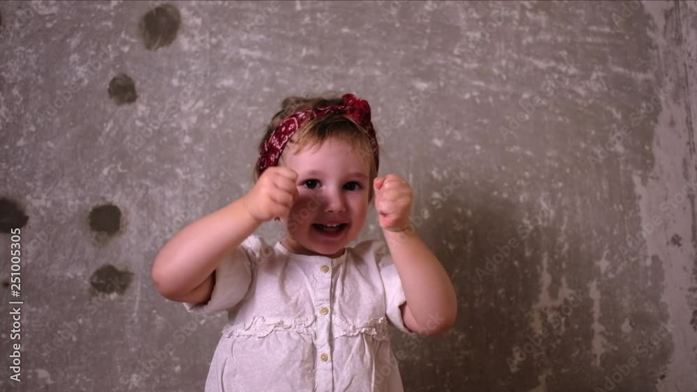 Cute little girl showing her hand muscles and then picking up Girl Power cardboard and showing peace sign Cute little girl showing her hand muscles and then picking up Girl Power cardboard and showing peace sign