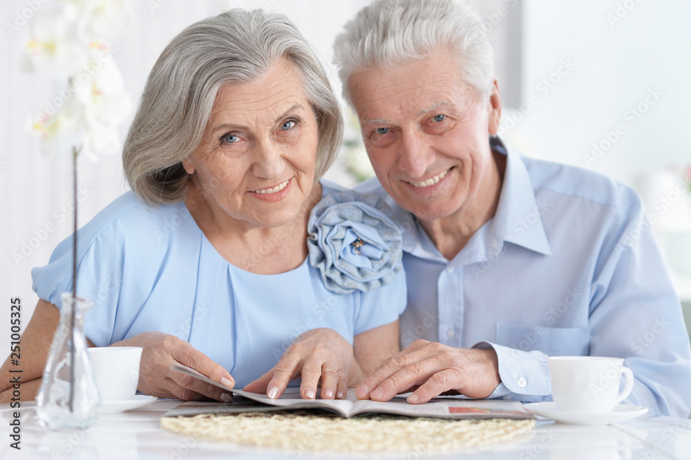 Portrait of mature couple with magazine drinking tea Portrait of mature couple with magazine drinking tea