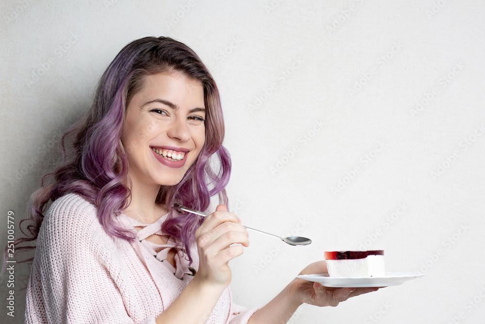 Cheerful young model with purple hair enjoying cheese cake with berries. Space for text Cheerful young model with purple hair enjoying cheese cake with berries. Space for text