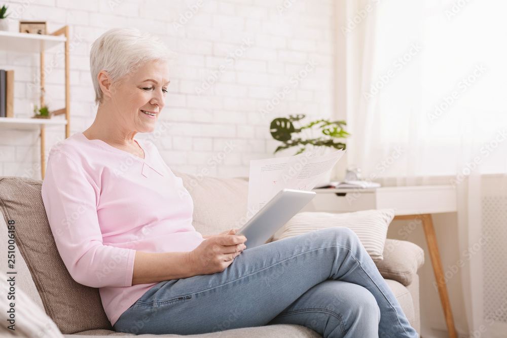 Senior woman working with documents and digital tablet Senior woman working with documents and digital tablet