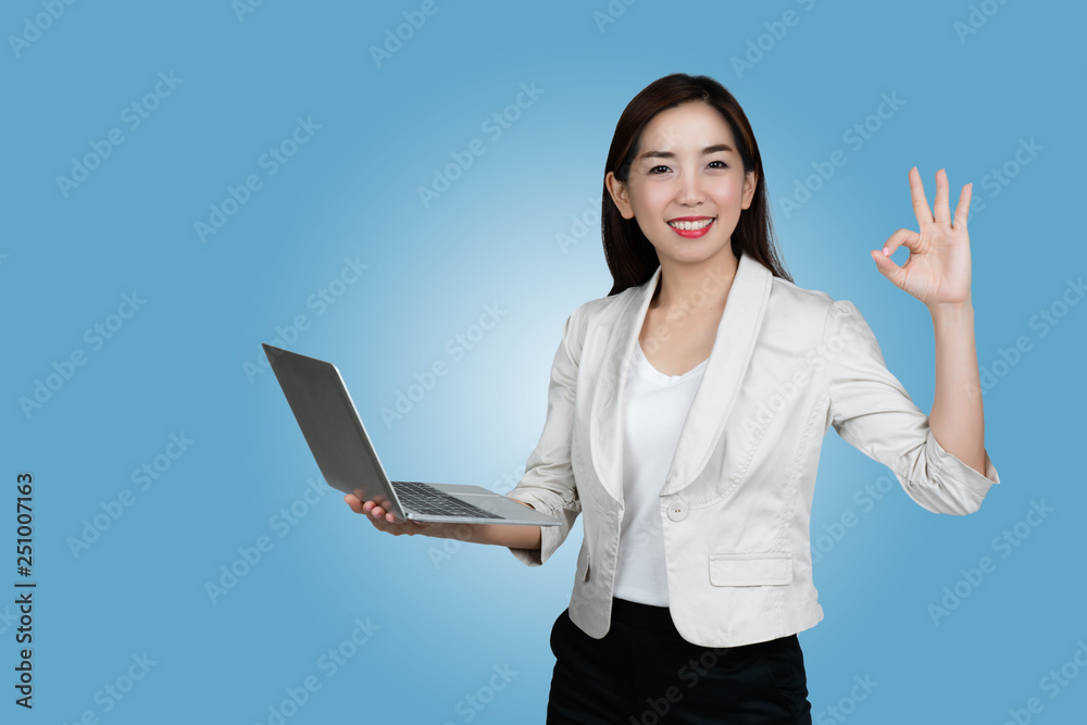 Asian business woman with a casual suit Hands holding a laptop By presenting the event to the meeting online And shopping online Quickly from the 5G system, Blue backdrop isolate Asian business woman with a casual suit Hands holding a laptop By presenting the event to the meeting online And shopping online Quickly from the 5G system, Blue backdrop isolate