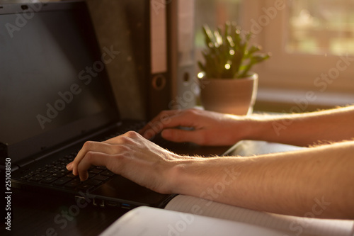 Junger Unternehmer schreibt in seinem modernen Büro an seinem Laptop © Lennart Worthmann