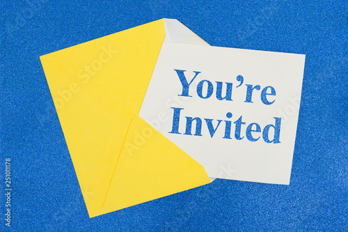 You're Invited message on white card with a yellow envelope