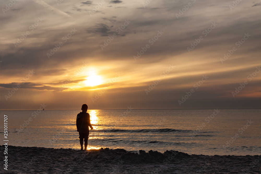 Child on the beach, sunset over polish sea baltic