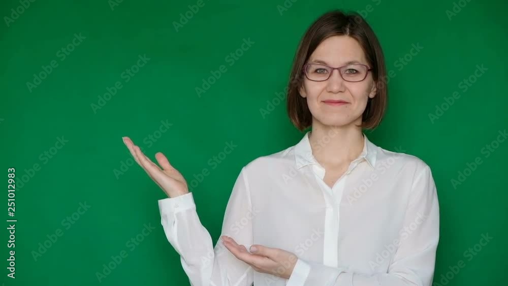 Beautiful smiling woman in glasses and white blouse pointing to the right on green screen, Chroma key Beautiful smiling woman in glasses and white blouse pointing to the right on green screen, Chroma key