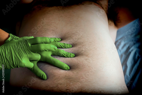 Slika na platnu Doctor preparing abdominal palpation in a hospital, conceptual image, horizontal