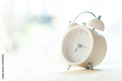 White alarm clock placed on a wooden table and to decorate the house