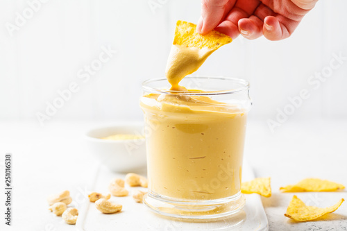 Vegan cashew cheese sauce in a glass, white background. photo