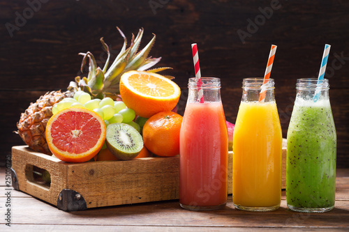 bottles of fruit juice and smoothie with fresh fruits photo