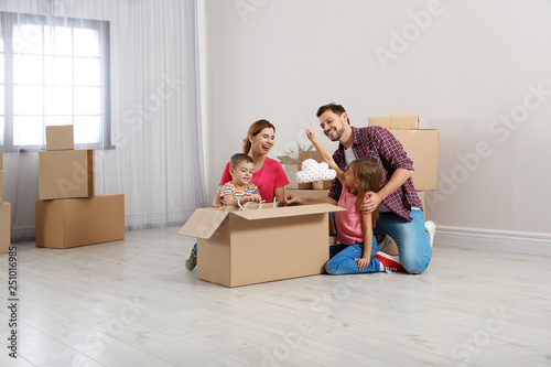 Family unpacking cardboard box in their new house. Moving day