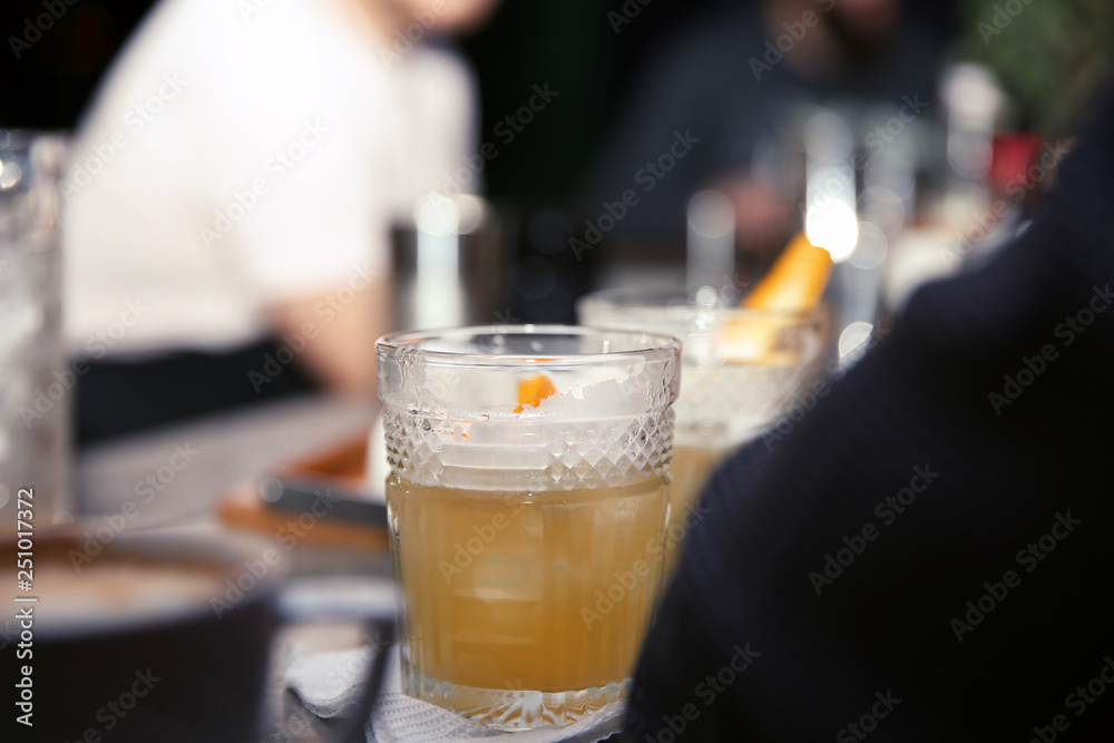 Glass of tasty cocktail on bar counter