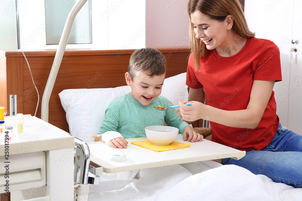 Woman feeding her little child with soup in hospital Woman feeding her little child with soup in hospital