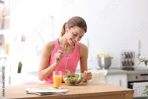 Young woman in fitness clothes having healthy breakfast at home