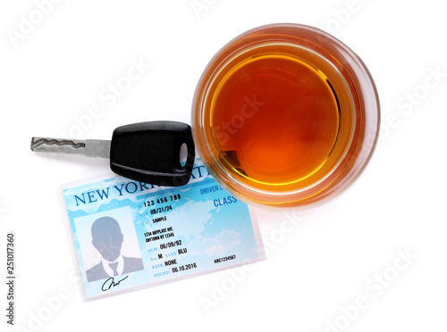 Glass of alcohol, car key and driver license on white background, top view. Responsible driving concept