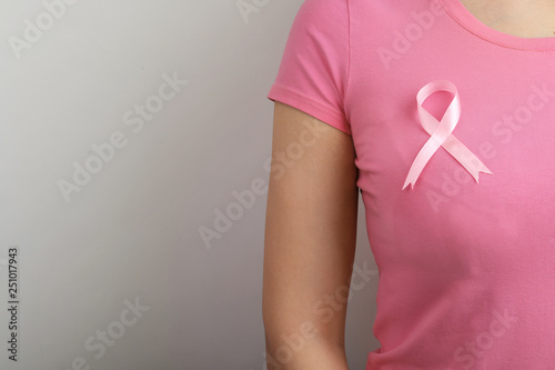 Obraz na płótnie Woman with pink ribbon on grey background, space for text